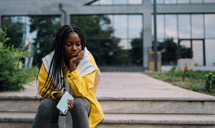 Sad young girl sitting on staircase and imagining. 